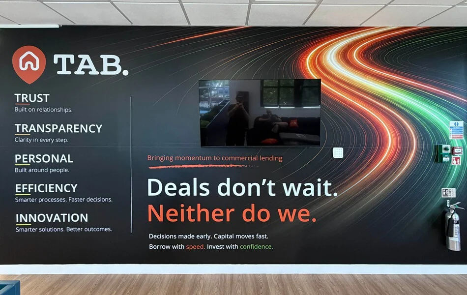 An image of the TAB floor to ceiling wall mural, including their motto and lights from moving cars.